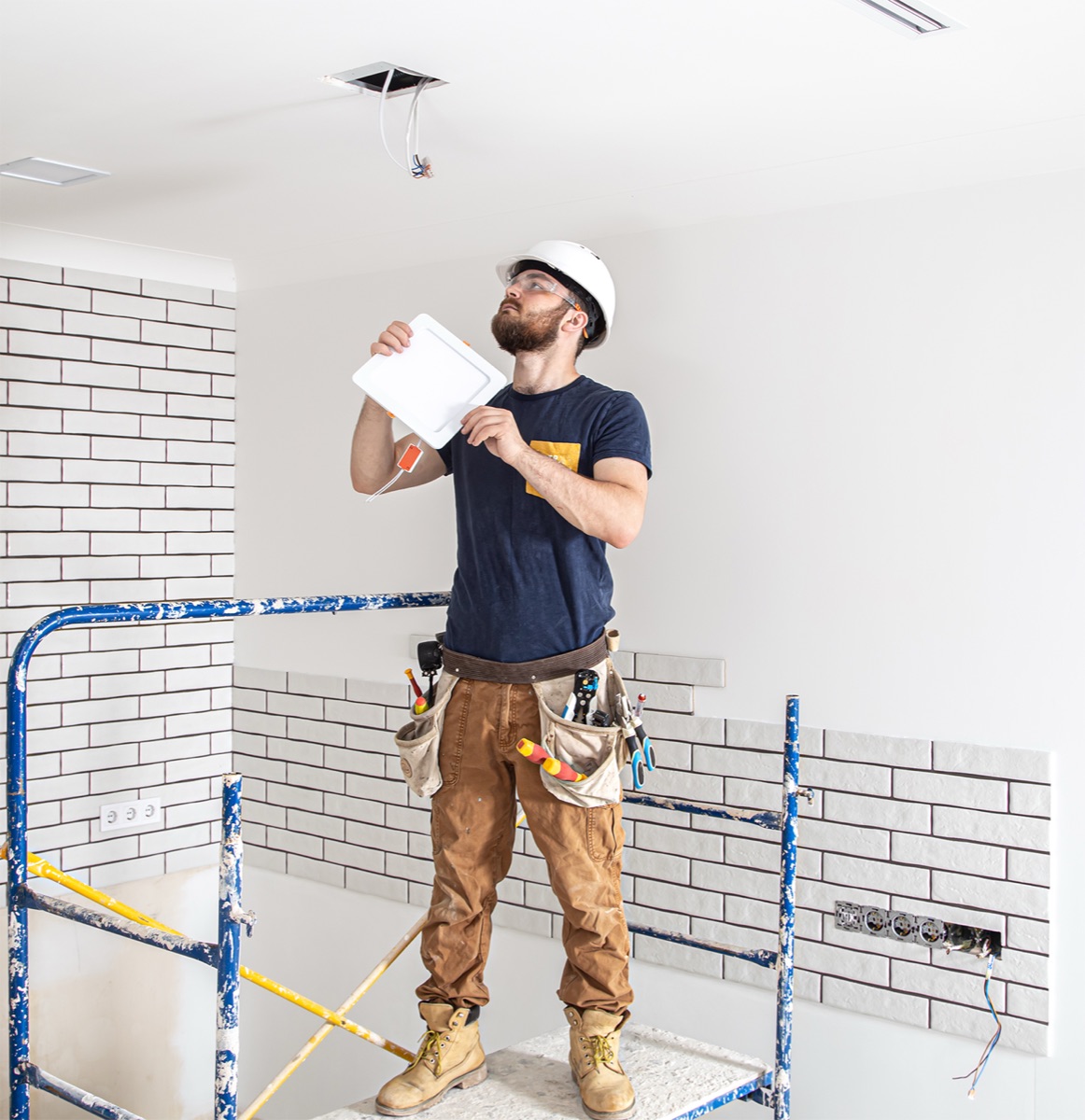 Electrician installing ceiling lighting
